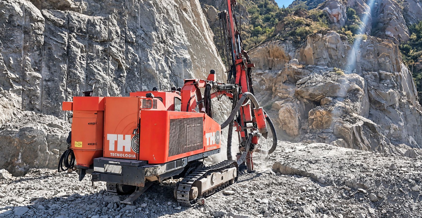 Equipo de perforación THOR operando al pie de un farallón rocoso en la precordillera.
